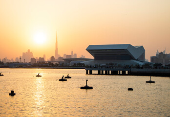 Sunset at Dubai Festival city. New building of Sheikh Muhammad Bin Rashid library on the scene as...