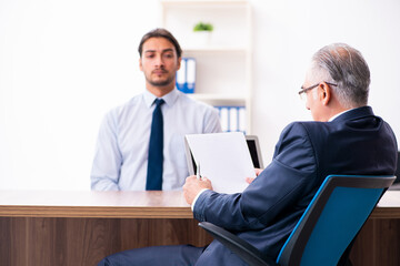 Obraz premium Young male candidate employee meeting with old recruiter