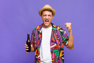 young handsome man shouting aggressively with an angry expression or with fists clenched...