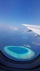 Fototapeta na wymiar Airplane wing in the sky. View in an elluminator on the Maldives