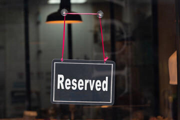 Reserved sign, reservation concept. Table tent, reserved text on a wooden table, banner, copy space.