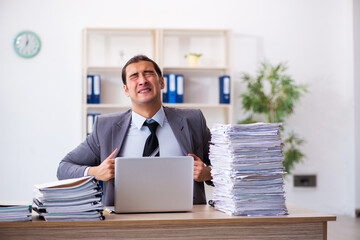 Fototapeta premium Young male employee unhappy with excessive work