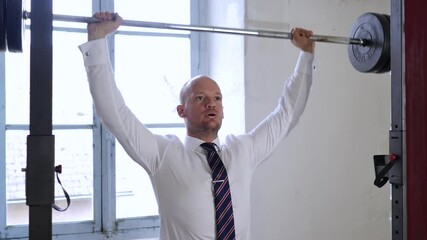 Businessman doing exercises with barbell in the gym. Hard working business concept. Strong businessman with dumbbell. Business training concept. fitness gym and bodybuilding fit motivation training. - Powered by Adobe