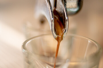 Coffee machine pouring coffee into a glass cup in close up concept