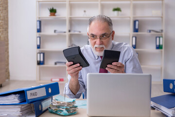 Old male accountant in budget planning concept in the office