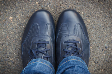 Comfortable navy blue leather shoes for men on asphalt road or footpath. Male footwear