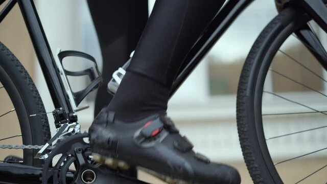 the cyclist wearing special shoes takes off his sneakers and contact pedals
