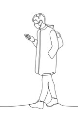 young man in a long jacket with a hood and a mask on his face walks down the street with a backpack on his back and looks at his phone. one line drawing of a man in a mask walking down the street