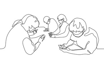 crowd of masked people are sitting staring at their gadgets. a group of people are sitting at the same table and are passionate about smartphones, they do not communicate with each other, they ignore