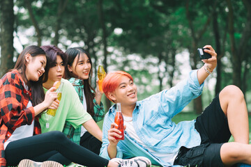 Group of happy young Asians are taking pictures check-in together at the park