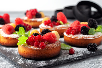 Fresh small homemade fruit tarts with raspberries, currants and blackberries