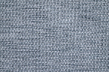 Woven surface close-up. Pale blue tinted fabric background or wallpaper. Top view from above. Light braided backdrop for sewing or handicraft. Macro