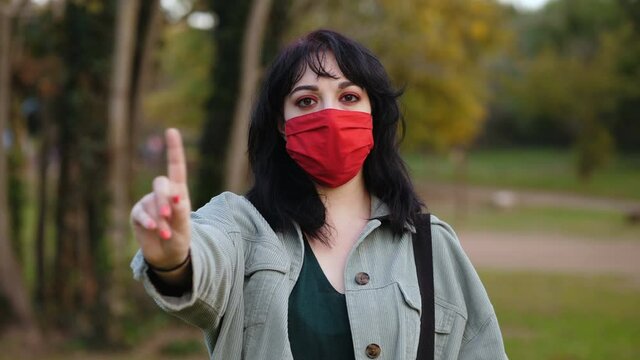 keep the distance - young woman with mask makes no to the camera