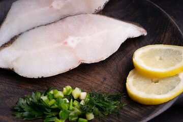 Frozen Greenland halibut steaks on the wood cutting board. Food background. Top view