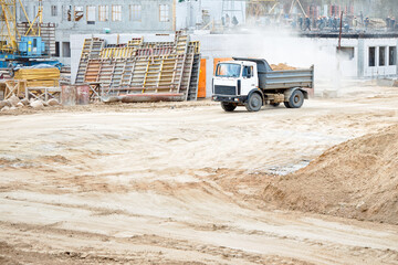 Multi-ton heavy mining dump truck loaded with cargo during removal of construction soil from construction site. Concept of providing transport shipping and freight for major construction projects.