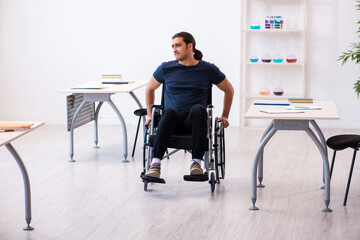 Young male student in wheel-chair preparing for exams