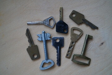 Close-up of old metal keys from doors (door locks) on a wooden background.