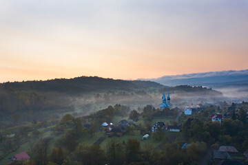 Aerial view over small rural village of Breb in magic sunrise.