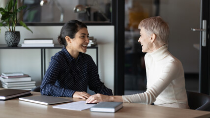 Happy diverse colleagues chatting during break, having pleasant conversation, laughing at joke,...