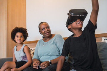 Grandmother and grandchildren playing together with VR glasses.