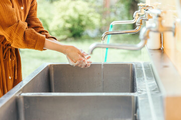水道で手を洗う女性
