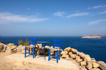 Fototapeta na wymiar Table and chairs overlooking the caldera in Santorini island. Cyclades, Greece