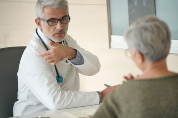 Obraz premium Mature doctor with patient in office, radiology