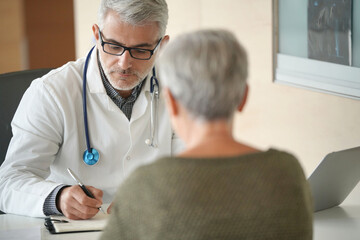 Obraz premium Mature doctor with patient in office, radiology