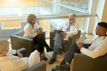 Medical people sitting in meeting room, checking planning together