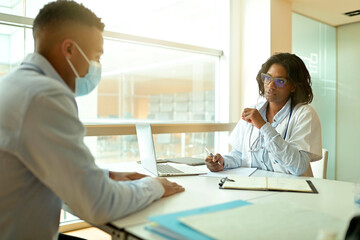 General practitioner with patient in office, check-up for 19-ncov