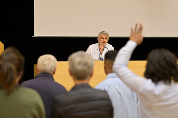 Doctor giving conference in convention center, audience in rear view