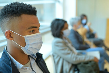 Patients sitting in waiting room with face mask, COVID-19 pandemic