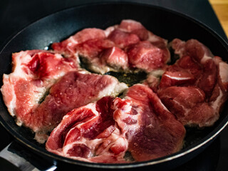 Pork steaks in frying pan 
