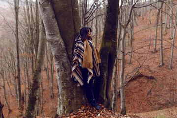 A woman is rest the autumn views on a cold day. Background with red crowns of trees in the autumn...