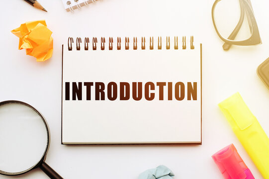 Introduction - word on notepad on table with glasses, magnifying glass and pencil.