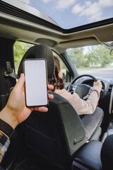 man hand holding phone with white screen woman driving car