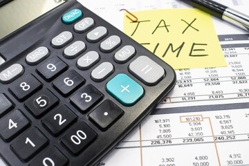 close-up of a black calculator that lies on financial documents and on a blurry background of a...