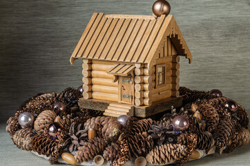 Mock-up of a wooden house in the center of a Christmas wreath in a natural style close-up. Christmas composition.