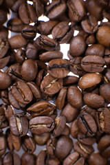 Coffee beans close up against the background of a coffee beans. Morning espresso. Coffee mug.	