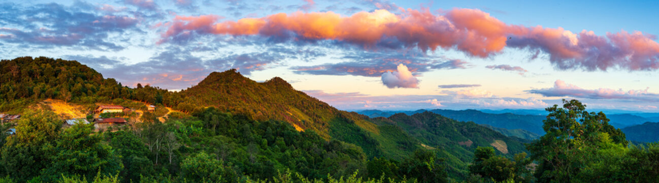 Akha village in the mountains of North Laos, sunset dramatic sky. Remote tribal village travel destination for tribal trekking, Akha ethnic group and minority.