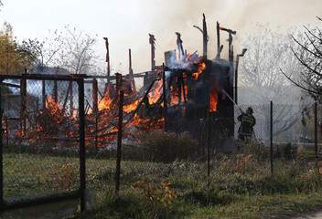 Firefighters extinguish a burning country house.