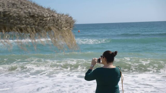 Woman taking picture of seaside in Costa del sol in Spain in 4k slow motion 60fps
