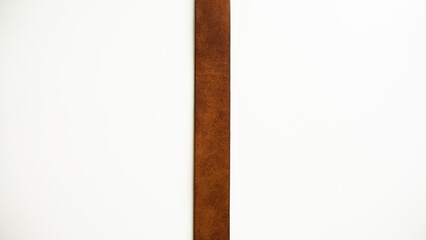 Dividing strip. Brown leather strap on a white background.