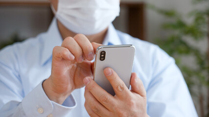 スマートフォンを使う中年男性