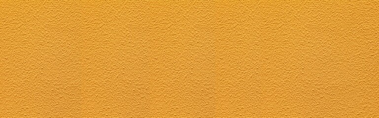 Panorama of The walls of the cement building are painted in yellow with rough patterns background seamless and texture