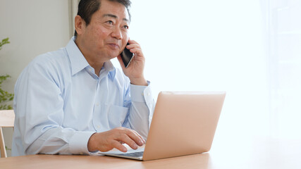 仕事の電話をする中年男性