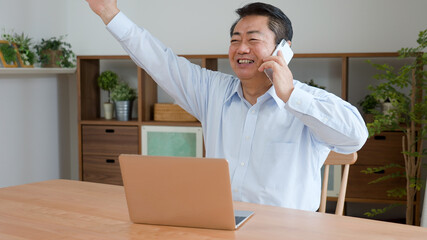 仕事の電話をする中年男性