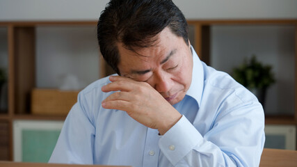ノートパソコンを使う老眼の中年男性