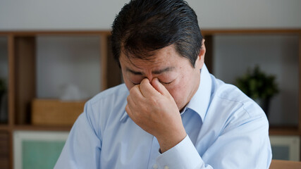 ノートパソコンを使う老眼の中年男性