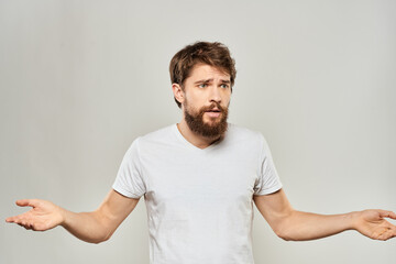 man in white t-shirt gesturing with his hands studio dissatisfaction lifestyle light background